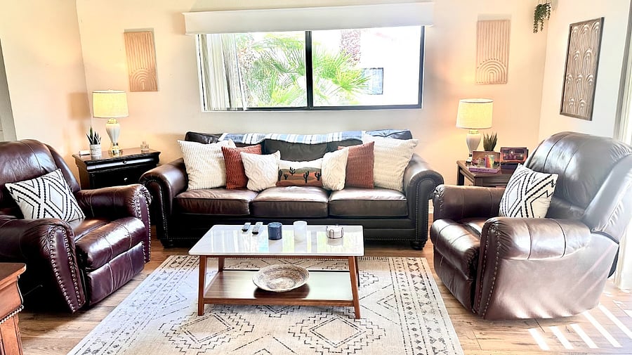 Our living room offers a warm and inviting space to relax, featuring a large leather couch and two plush recliners perfect for unwinding.