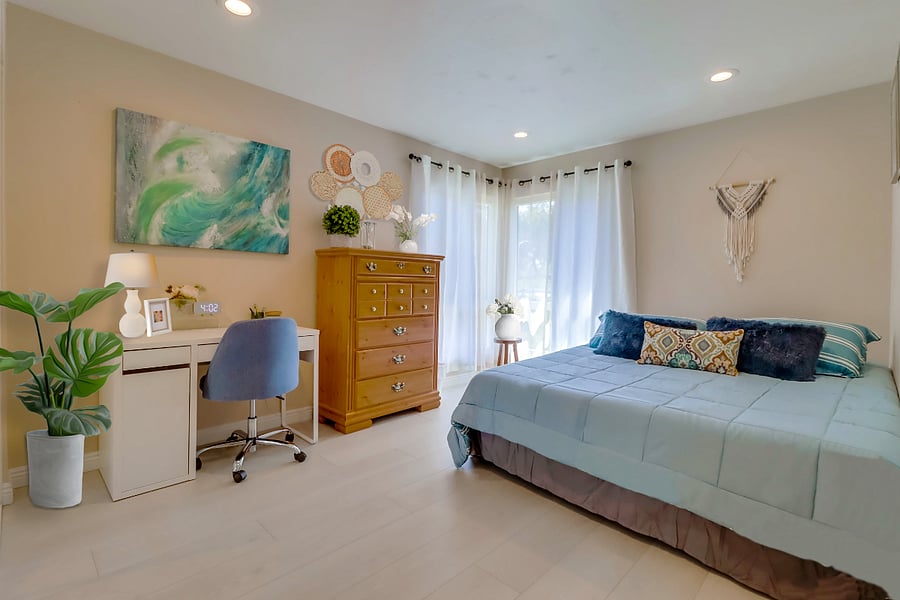 Enjoy lots of natural light in Bedroom 1 with a cozy queen bed & nearby workspace