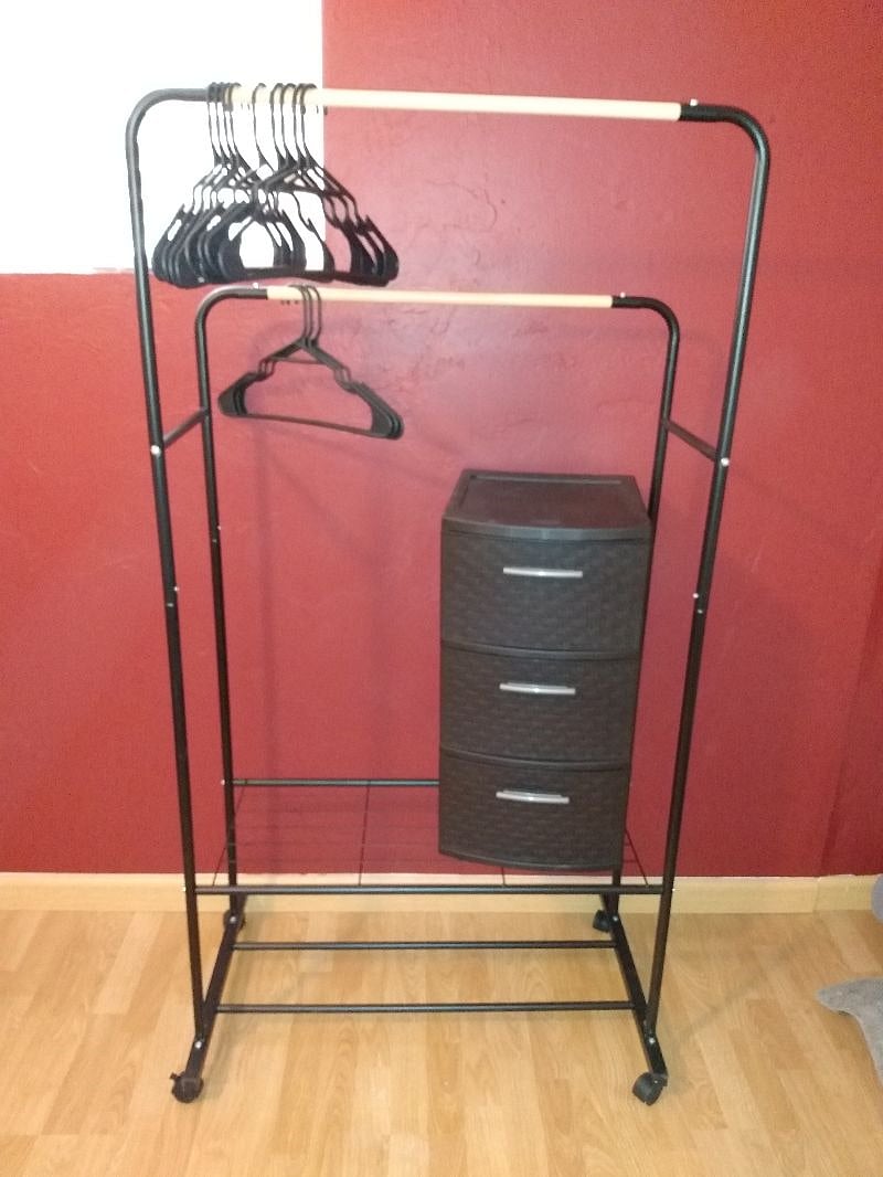 Twin bedroom has a spacious garment rack for storage. 