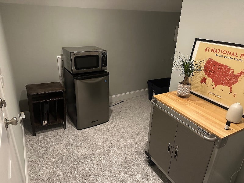 Mini-fridge and microwave. Coffee pot and other cooking appliances and dinner ware in storage cabinet.