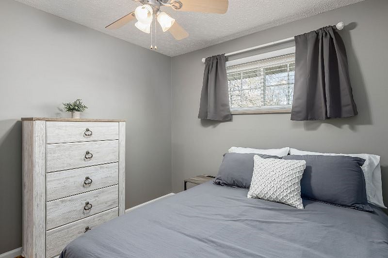 View of 3rd bedroom that includes a full size bed with memory foam mattress, 5 drawer chest dresser, 1 nightstand with USB/outlets built in, blackout curtains.