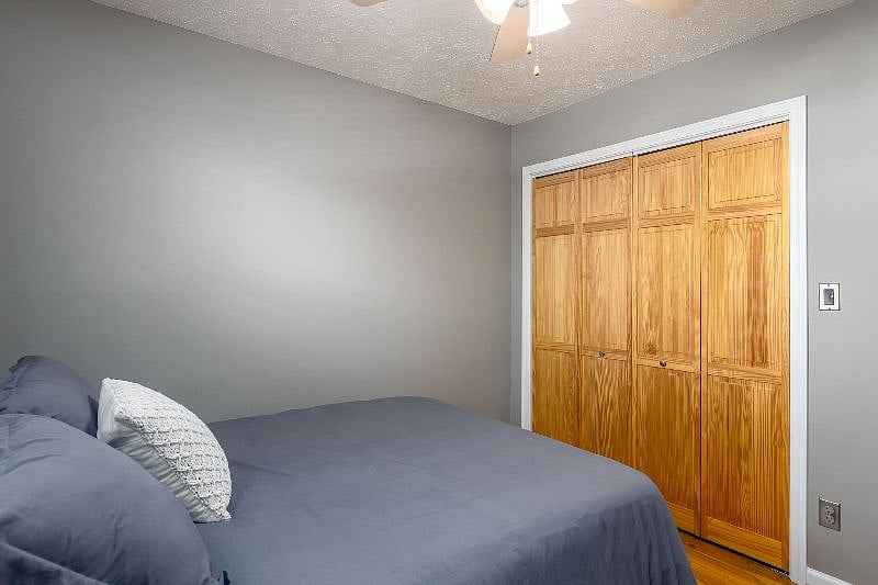 Additional view of 3rd bedroom with closet that includes ironing board and iron.