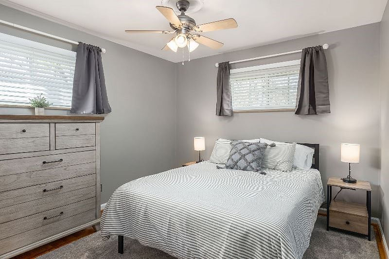 View of 2nd bedroom that includes queen size bed with memory foam mattress and 5 drawer chest dresser. Blackout curtains. Nightstands have built in USB/outlets to make it easy to charge your devices.