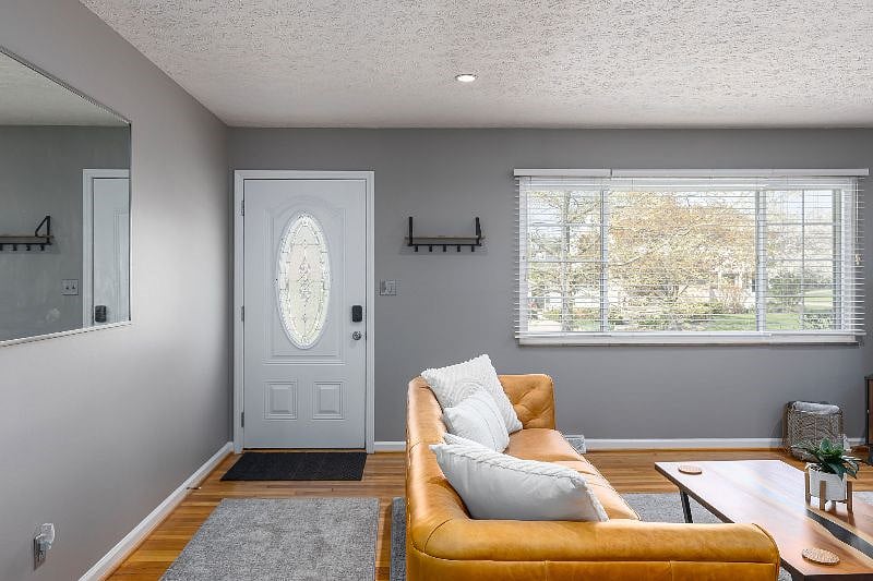 View of front door and window that lets in plenty of sunlight 