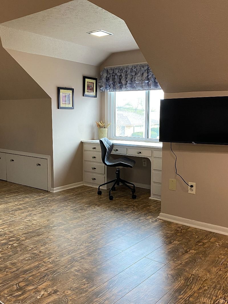 Work surface in a well lit alcove with daylight and over head light.  Desk lamp has phone charger.