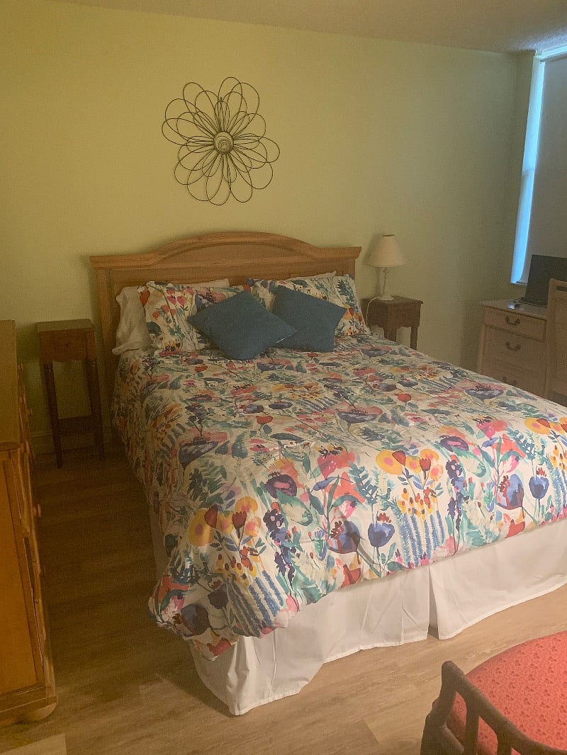 Guest bedroom with Queen bed, desk, dresser and closet.