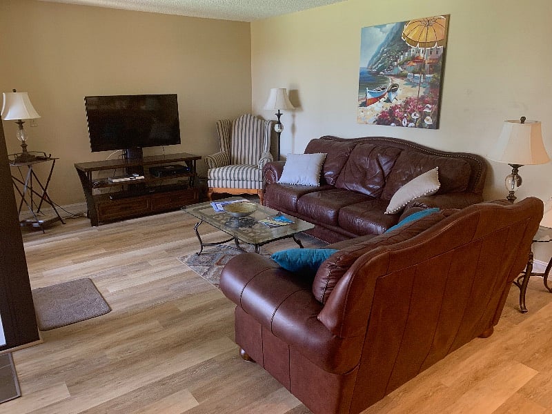 Living Room with plenty of seating , large smart TV - access to balcony - open floor plan to kitchen , dining area - beautiful view of lake, fountain and walking paths