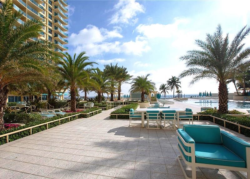 Pool deck by pool. Part of an extended park like area. Tables and nook areas, so everybody can have their own privacy.