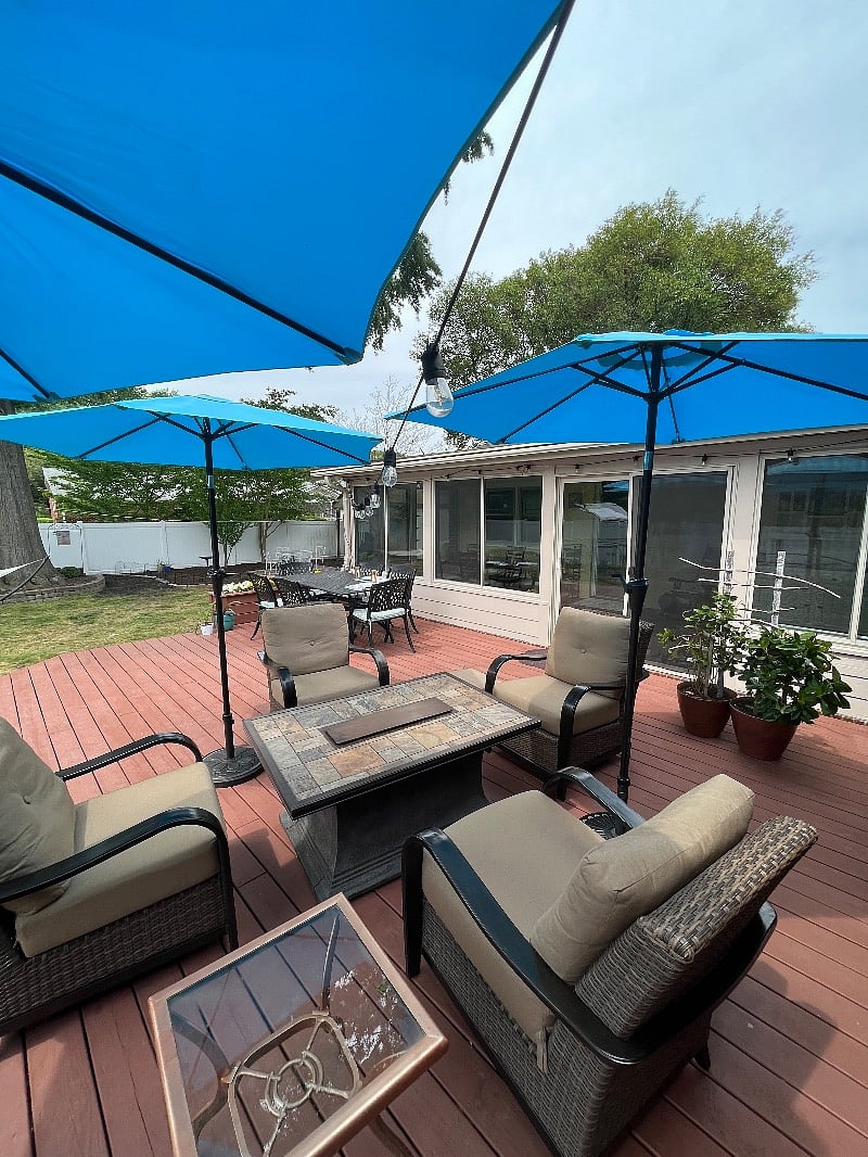 Wooden Deck with furniture, sun-brellas, dining table.