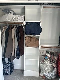 Full size closet with hanging area with cupboard area for shoes, sweaters, etc