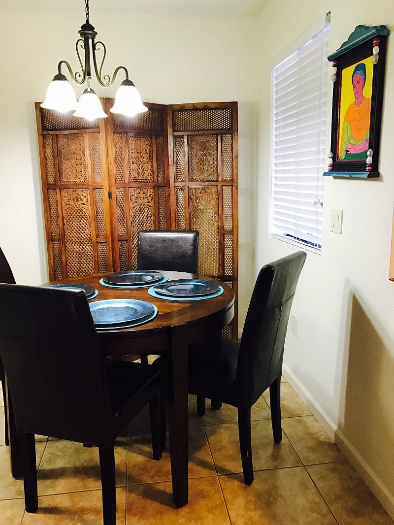 Dining area with table and seating for four.