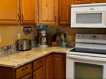 Well stocked kitchen complete with a kitchen aid mixer, microwave, and coffee maker