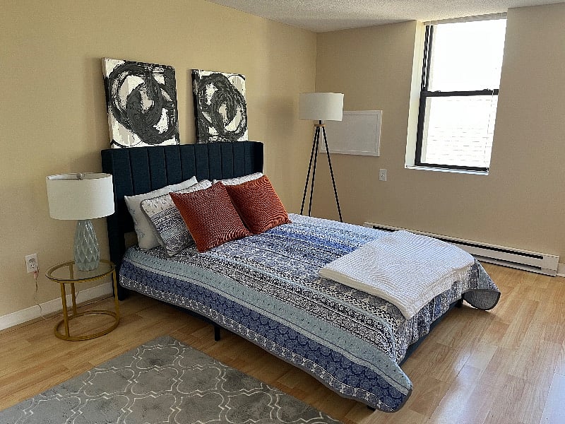 Sizeable bedroom features a queen bed with ample dresser and closet space. 