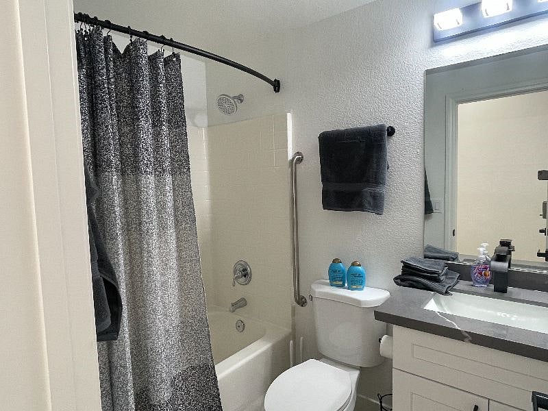 Full bathroom with accessible bars and tub