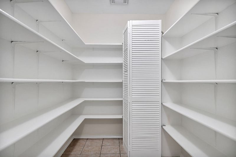 Walk-in pantry and laundry room attached to the kitchen. Open shelving for personal storage use.