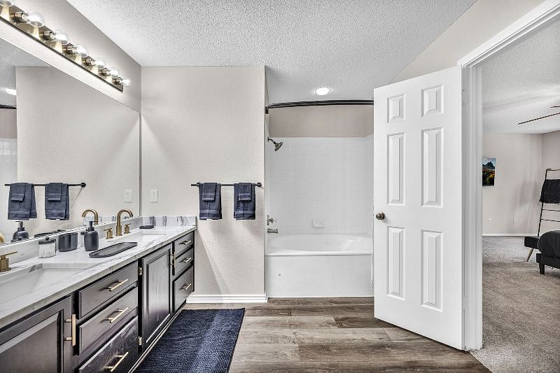Master bathroom includes a large vanity with double sinks and a jacuzzi bathtub with shower combo.