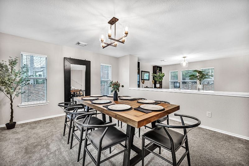 Dining room featuring a hanging chandelier and large 6 foot mirror.