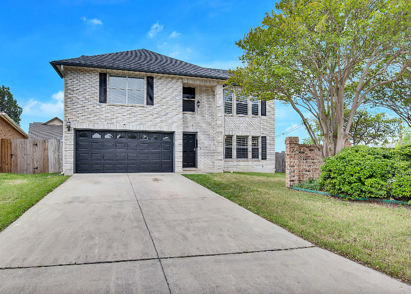 Front of the house features a spacious driveway for 2 cars and an open 2 car garage for parking.