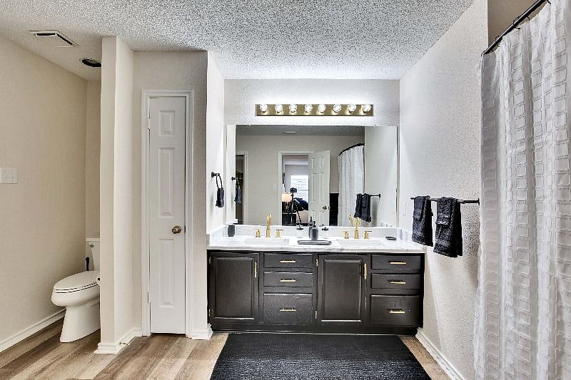 Spacious master bathroom with cabinets and linen closet for storage.