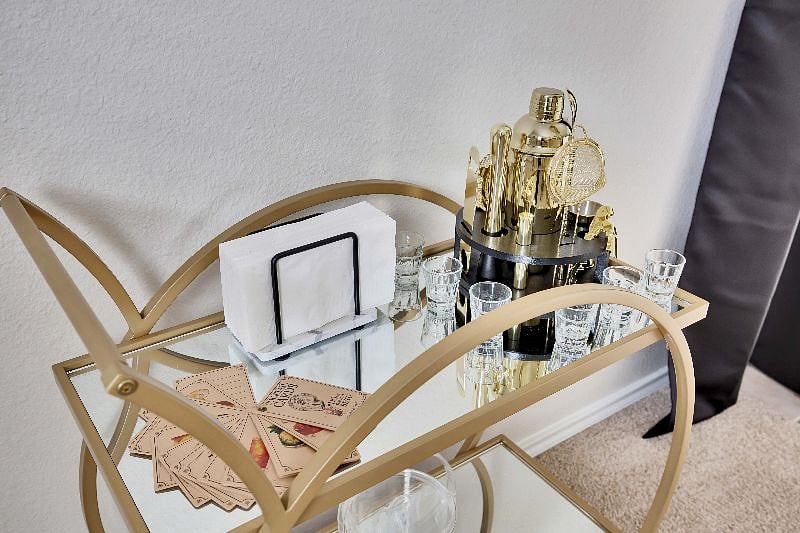Bar cart complete with shaker and mixing kit, ice bucket, small glasses and recipe cards.