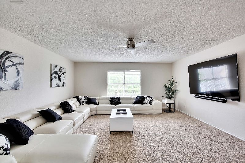 Upstairs media room features large leather sectional and 85 inch Sony 4K Smart TV with Sonos Arc sound system for the ultimate home entertainment experience.