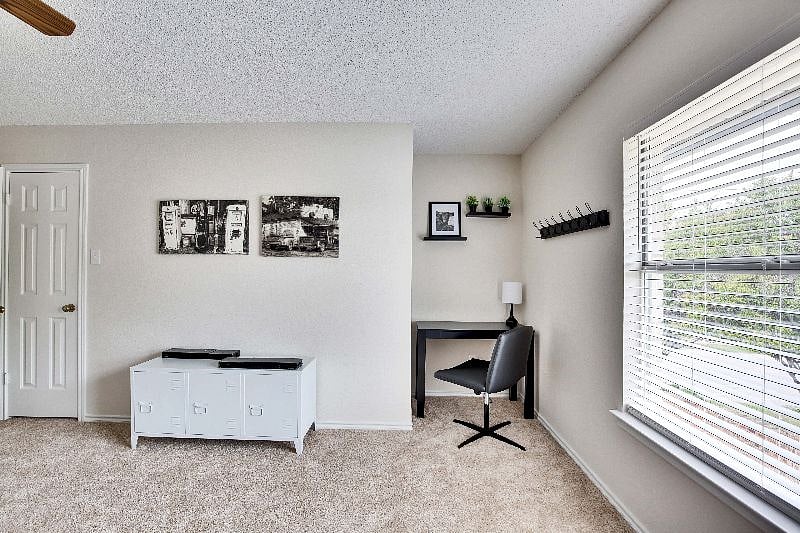 A work space complete with a desk, small lamp and a leather swivel chair is in the third bedroom.