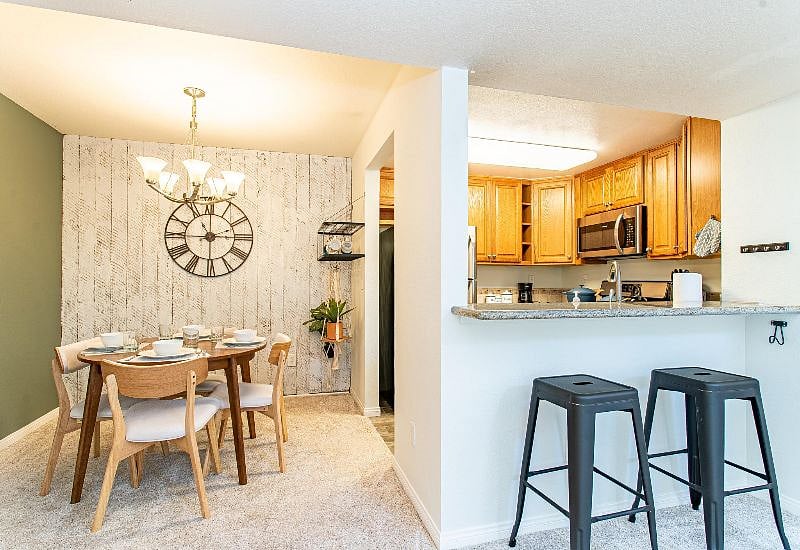 Dining table and split level kitchen countertop with bar stools provide plenty of options for places to eat at home