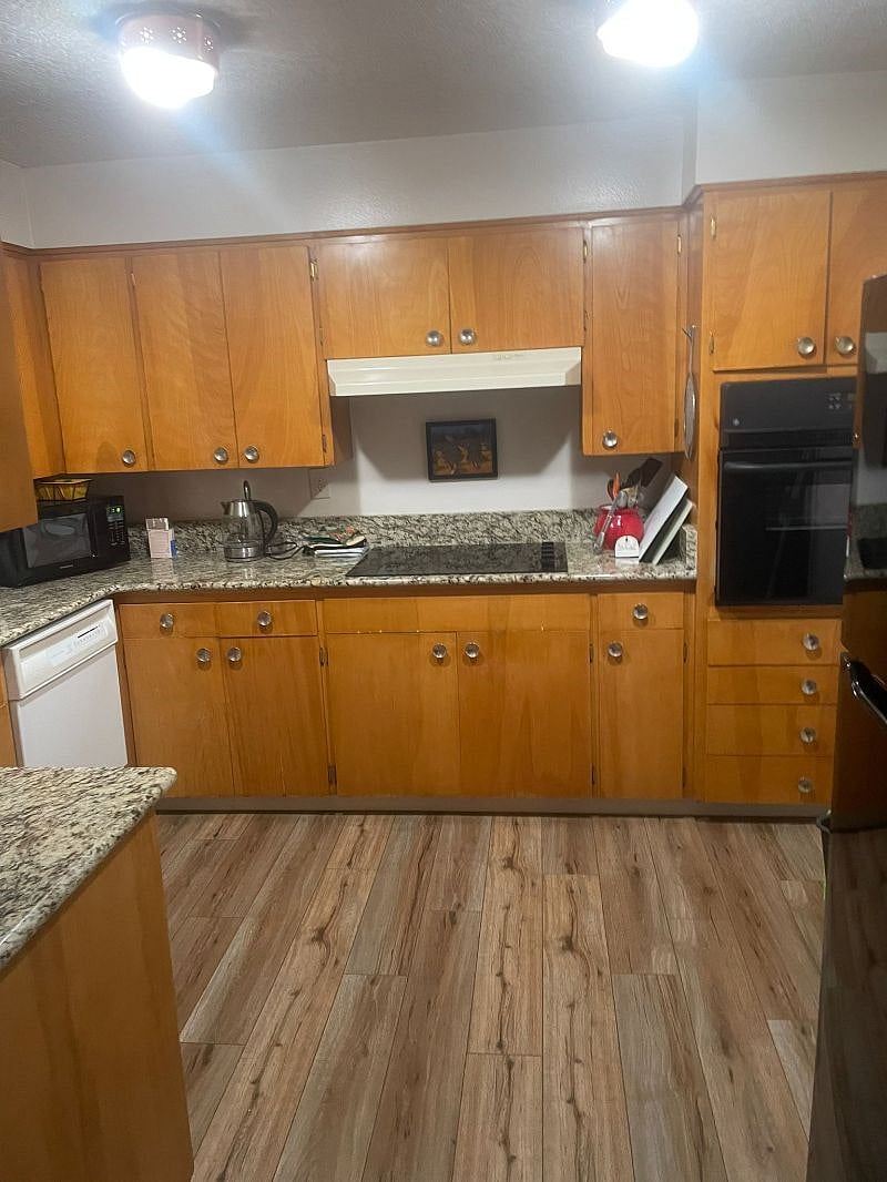 Kitchen with stovetop, dishwasher, oven, refrigerator, fully equipped.