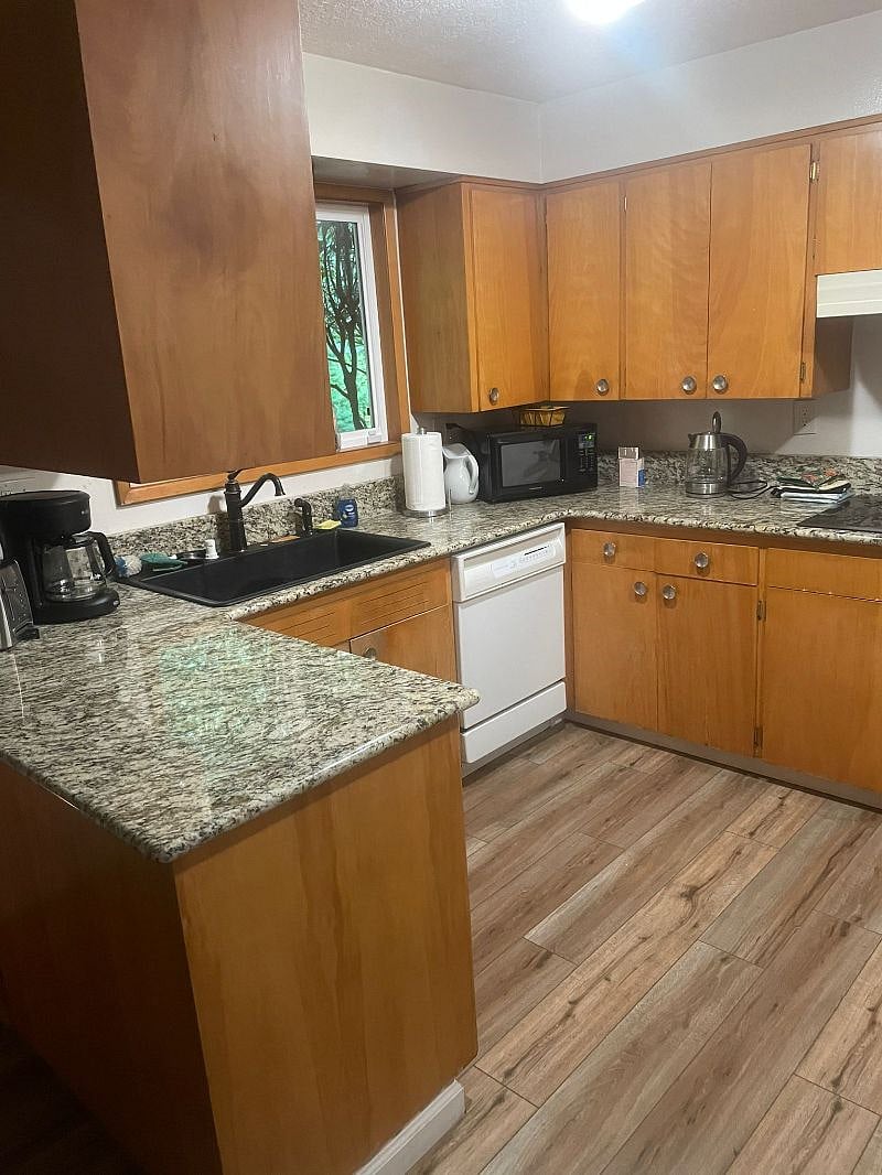 Kitchen with stovetop, dishwasher, oven, refrigerator, fully equipped.