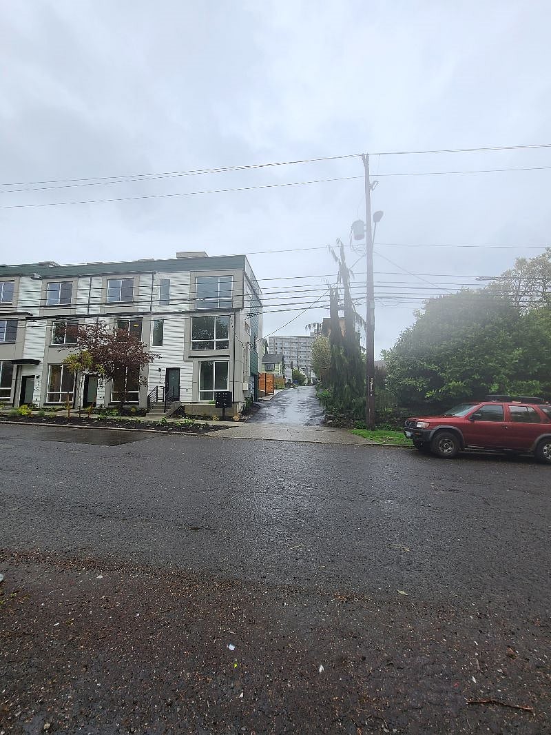 see green house in alley where parking is located. Main door is on the street at the end of the alley,