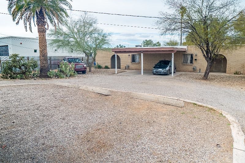 Left side of duplex, which includes 1 covered parking space. Add'l parking available to left (west) side of lot, and 3-car parking lot on main road (southern portion of lot, photo foreground).