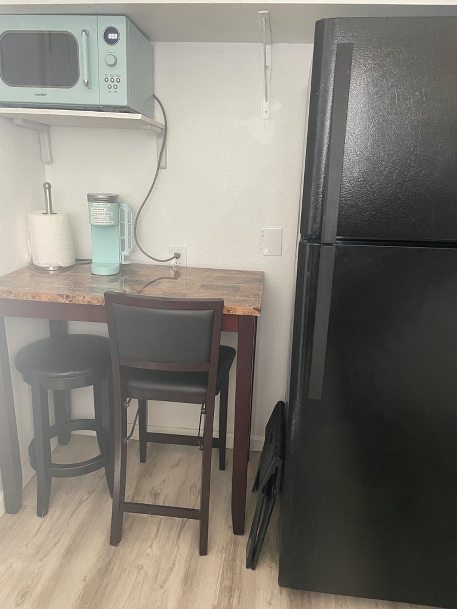 View of -
Table/laptop
-Full size fridge on right
-microwave
-keurig coffee maker