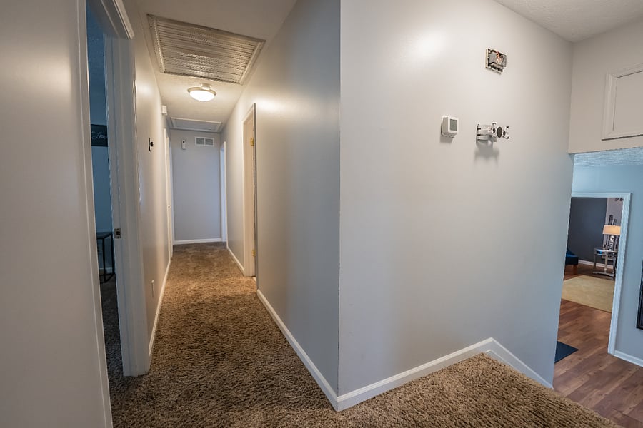 Carpeted hallway connecting the homes bedrooms and living spaces for easy, private flow throughout the house.