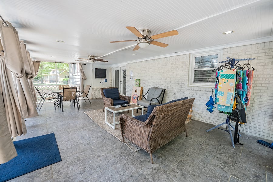 Relaxing covered sunroom with comfortable wicker seating a great place to unwind and enjoy the outdoors in comfort.