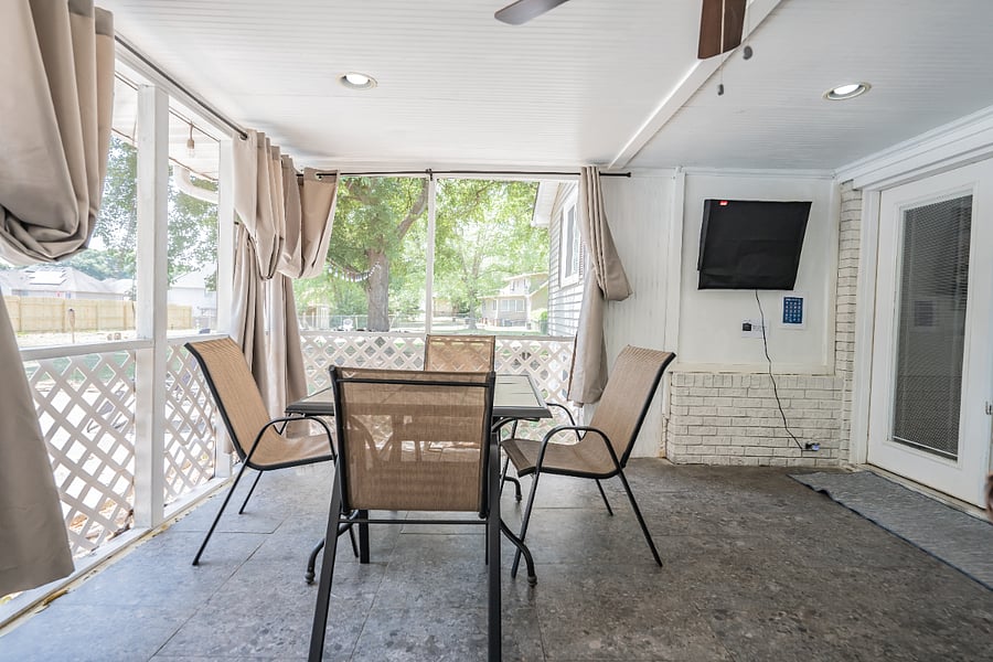 Screened-in porch with a patio dining set, ideal for outdoor meals and morning coffee while staying shaded and bug-free.