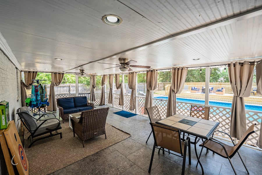 Spacious covered patio with lounge seating and a view of the pool area perfect for outdoor entertainment and relaxation.