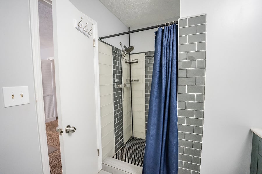 Clean full bathroom featuring a tiled walk-in shower with a glass surround for a refreshing start to the day.