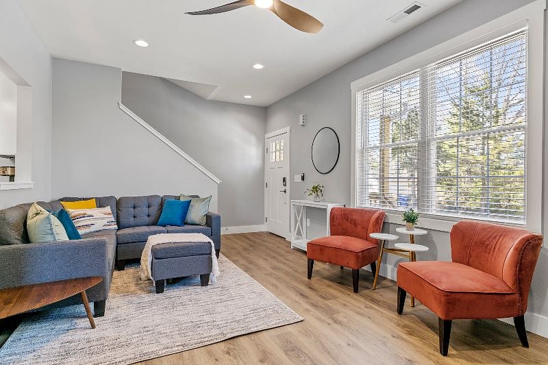 Alternate view of living area, with entry door and steps to the upstairs.