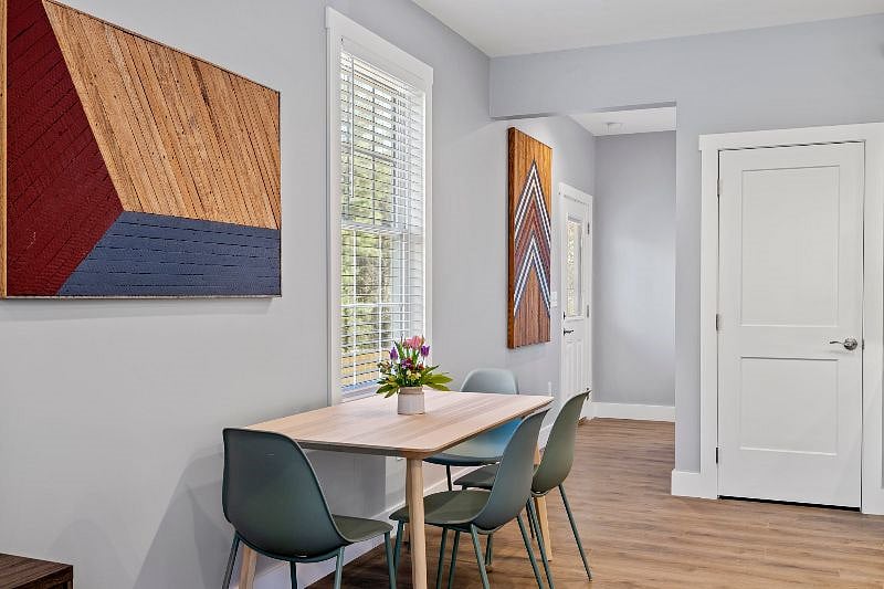 Dining table and chairs can seat up to 6! More chairs available. View of hallway to access the back patio, queen bedroom and full bathroom as well.