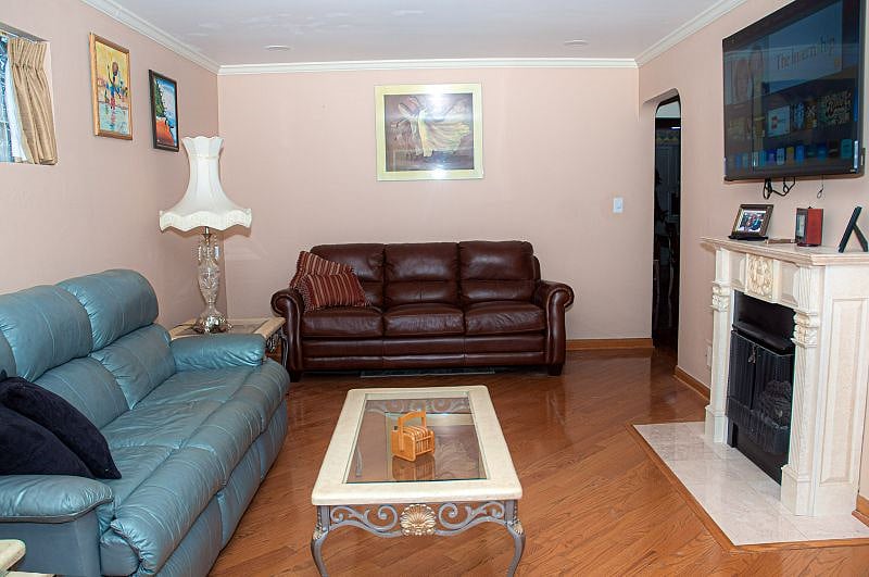 Front living room is cozy with hard wood floors, 65 inch smart TV and recessed lighting to watch movies in theater mode.