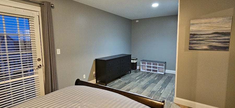 Master bedroom includes dresser, shoe storage, small closet and rolling clothing rack