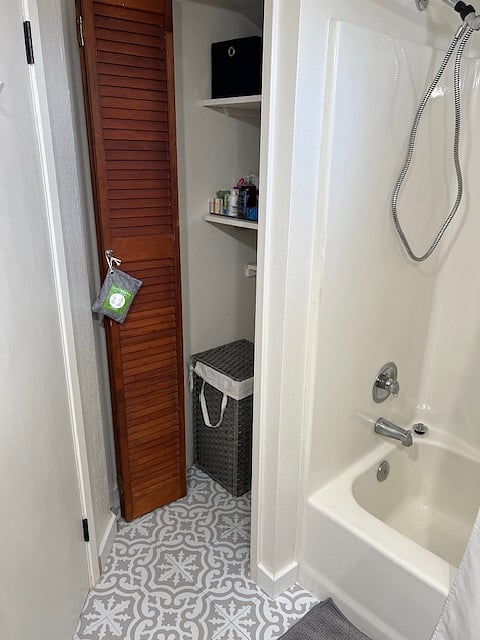 Bathroom closet with extra storage and hamper