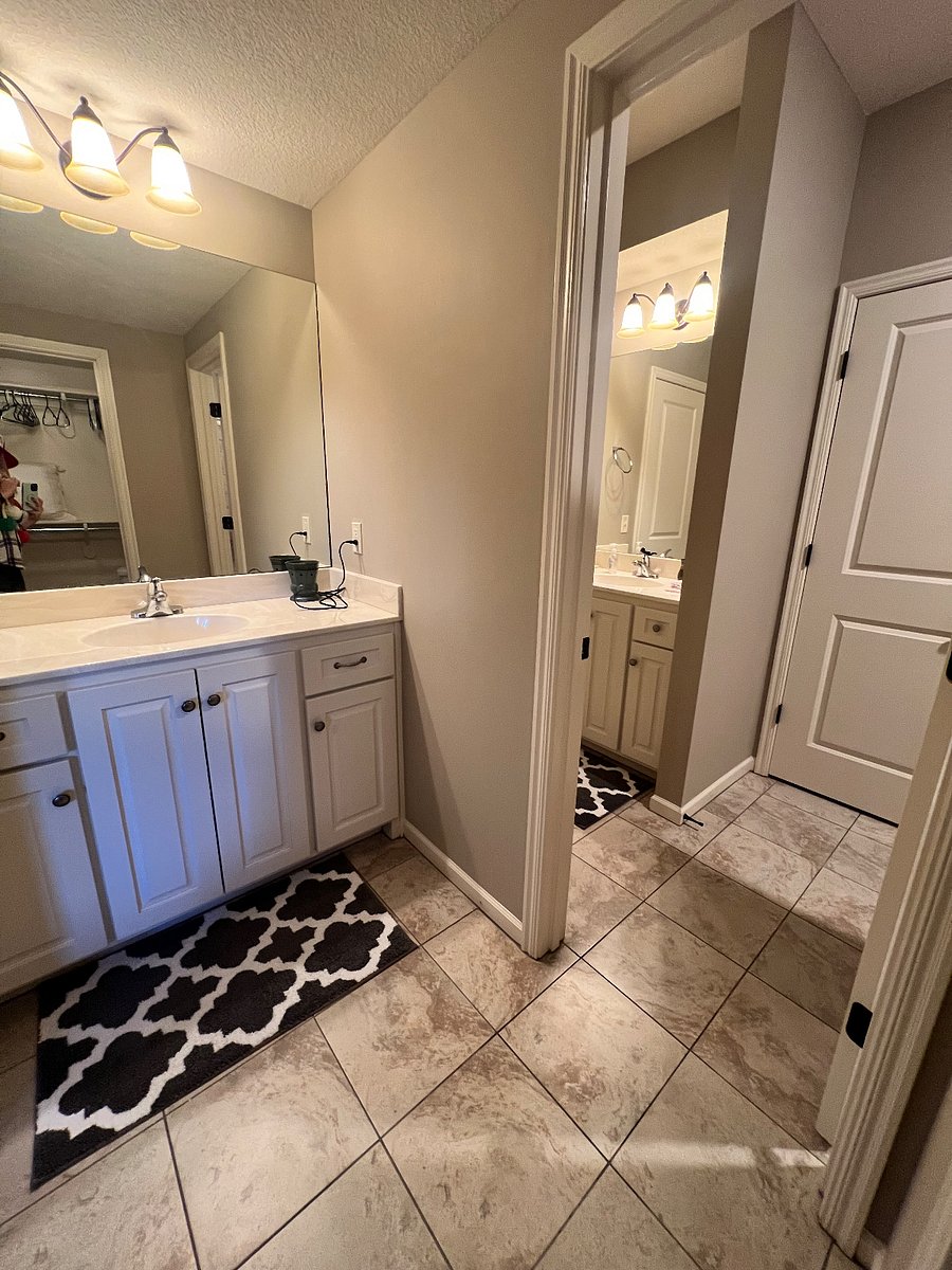 Private sink with door to shared bathroom space
