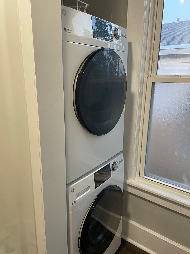 washer and dryer located in the bathroom next to the shower