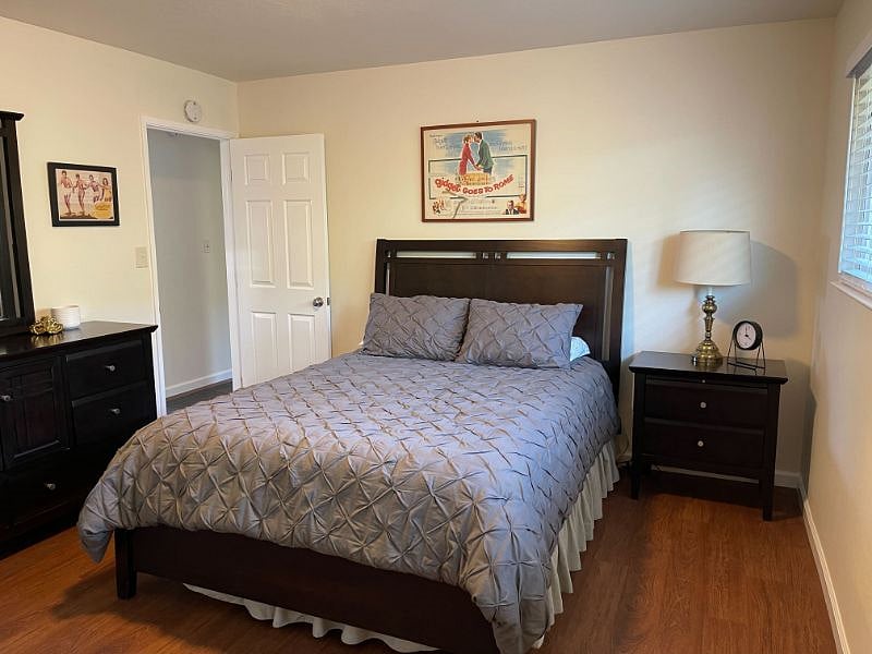 Bedroom with queen size bed, side table & dresser.