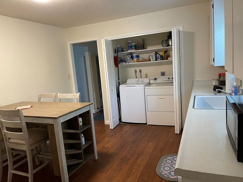Full washer & dryer in kitchen with closet doors.