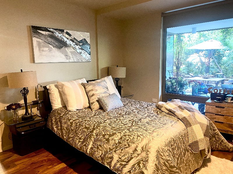 The master bedroom with a plush queen size bed looks over the backyard patio. It has a large walk-in closet and a office desk to do your work looking over the beautiful garden view.