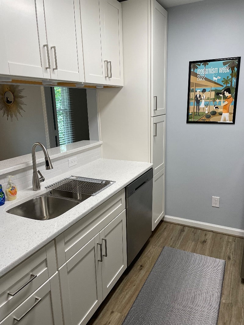 Full pantry, quartz countertops, tile backsplash, and stainless appliances with convection range, dishwasher, microwave, and ice maker.