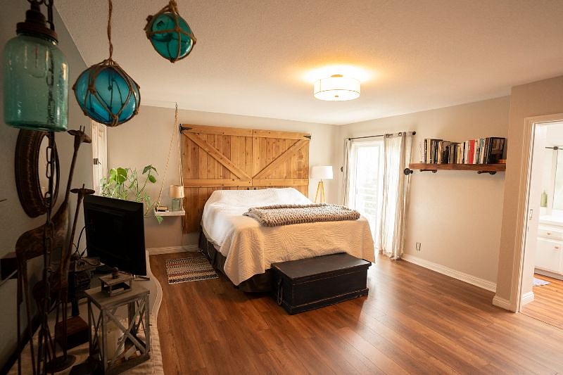 Master Bedroom suite (2nd floor) with king bed. View to outside patio with two chairs.