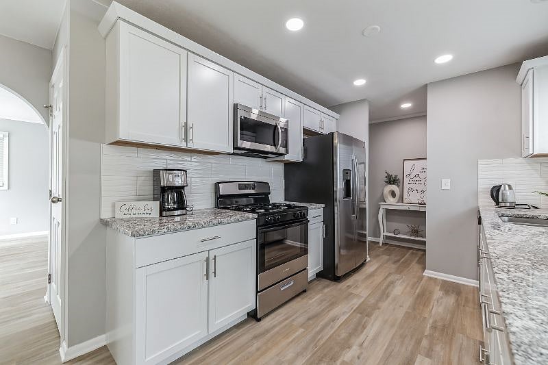 Kitchen with granite countertops and stainless-steel appliances, stocked with everything you need to feel at home.